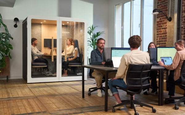 Modern office with a glass-walled meeting room and people at desks
